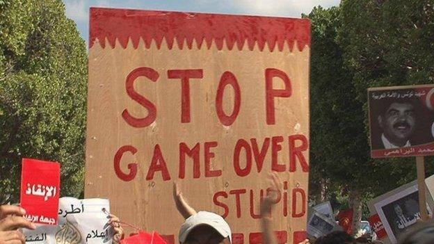 Slogan on placard in anti-government demonstration in Tunis reading "Stop, game over."