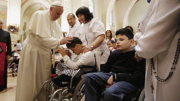 Pope Francis blesses a disabled person during his visit at the Serafico Institue in Assisi on 4 October 2013