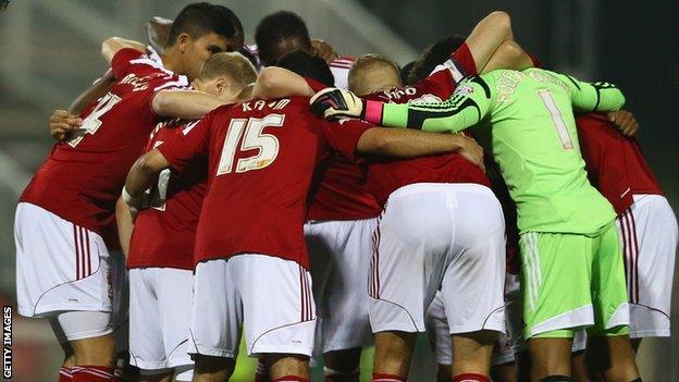 Swindon players huddle before the League Cup clash with Chelsea