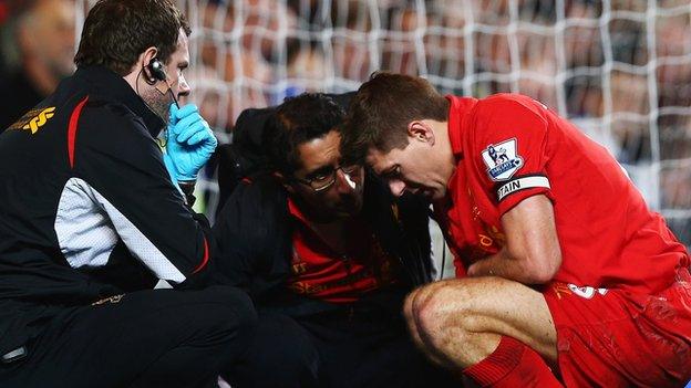 Steven Gerrard receives treatment from Zaf Iqbal on the pitch at Stamford Bridge