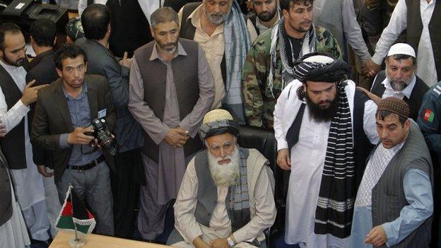 Afghan Mujahideen leader Abdul Rassoul Sayyaf (C, seated) waits to register as a candidate for the presidential election at Afghanistan"s Independent Election Commission (IEC) in Kabul October 3, 2013.