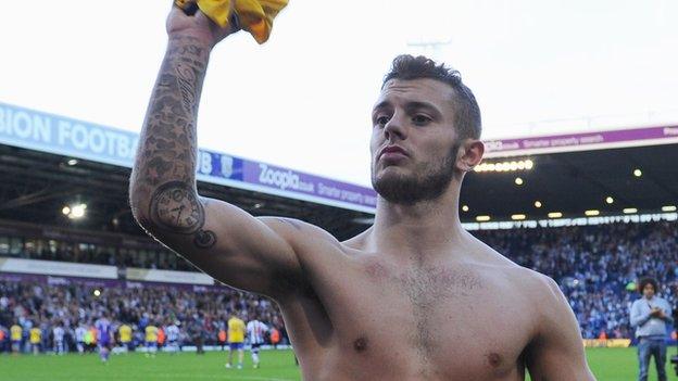 Arsenal midfielder Jack Wilshere throws his shirt to Gunners fans after his side's draw at West Brom