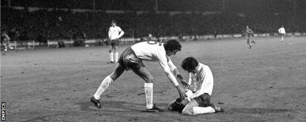 Roy McFarland retrieves the ball from a devastated Norman Hunter after Poland's goal