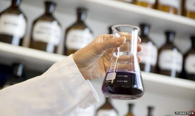 Scientist holding beaker