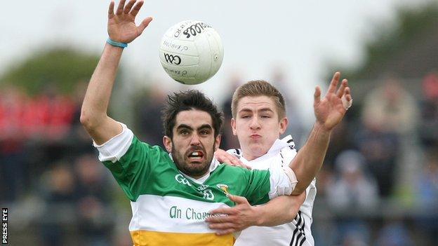 Carrickmore's Michael McCallan battles with Clonoe's Dwayne Quinn