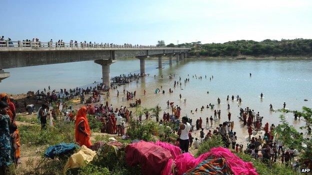 Hindu pilgrims take a "holy dip" in the Sindh river alongside the bridge where a deadly stampede took place the previous day in Madhya Pradesh on October 14, 2103