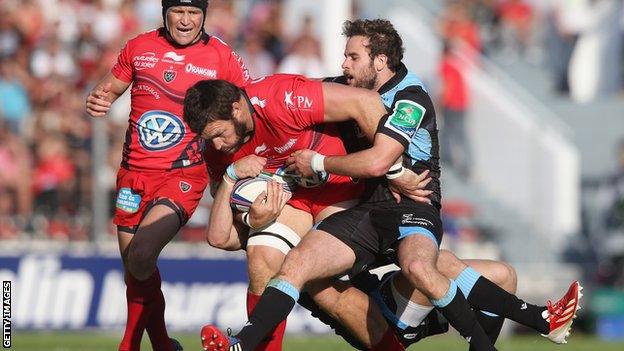 Daniel Rossouw of Toulon is tackled by Ruaridh Jackson and Byron McGuigan