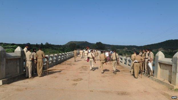 policemen walk on the bridge where a deadly stampede took place the previous day near the Ratangarh temple in the Datia district of central Madhya Pradesh on October 14, 2103