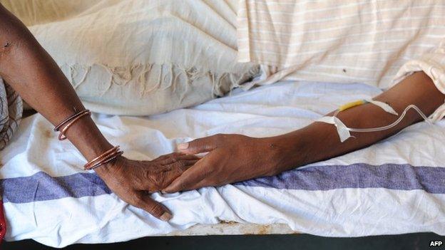 An Indian Hindu pilgrim holds her injured son's hand at a hospital at Seondha