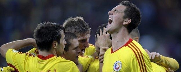 Romania celebrate their crucial second goal against Estonia