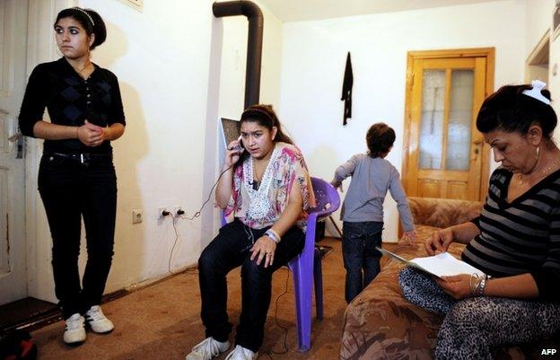 Leonarda Dibrani sits at her home with her family members in the town of Mitrovica, Kosovo, 16 October