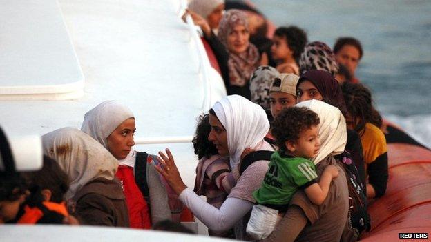 Migrants are seen on Coast Guard rescue boat with a group that includes Syrian refugees, at Siracusa harbour on the island of Sicily 20 September 2013