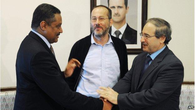 Canadian Carl Campeau (C) standing between Syrian deputy Foreign Minister Faisal Muqdad (R) and the UN representative in Syria Wassim Kheir Beik (L), in Damascus (17 Oct 2013)