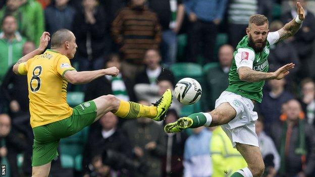 Celtic midfielder Scott Brown and Hibs forward Rowan Vine in a high challenge