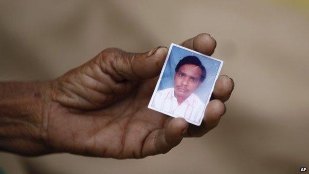 Indian woman Taradevi displays a photograph of her 22-year-old son Umesh Gaur who died after drinking toxic bootleg liquor at Atardiha village in Azamgarh district