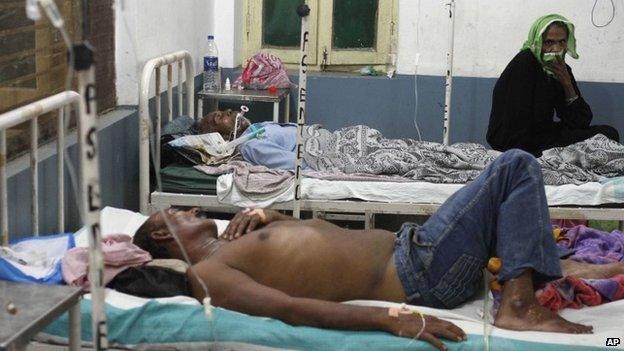 Indians receive treatment after falling ill from consuming tainted liquor, at a hospital in Azamgarh, India, Saturday, Oct. 19, 2013
