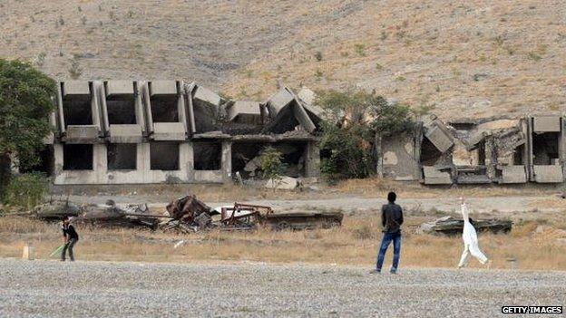 Afghans play cricket in front of a ruined Ministry of Agriculture building in western Kabul in 2009