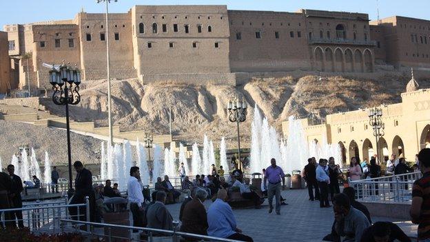 People sitting in Irbil square with fountains and backdrop