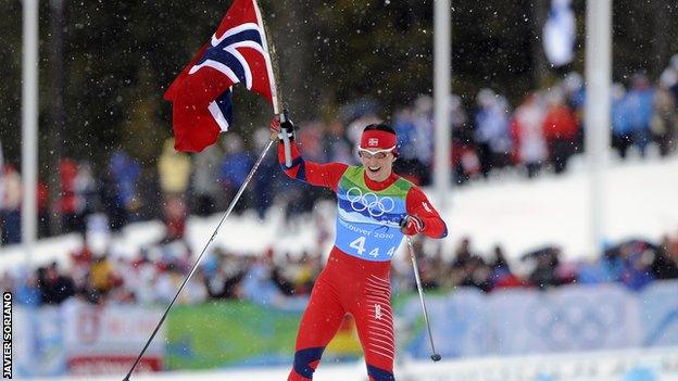 Marit Bjoergen celebrates after winning one of a record five medals at the Vancouver Olympics