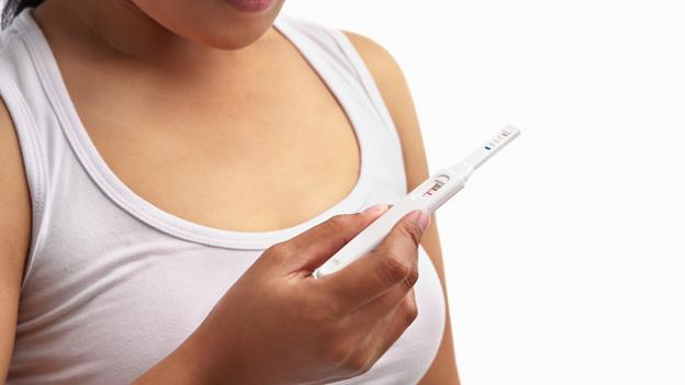 A woman checking a pregnancy test