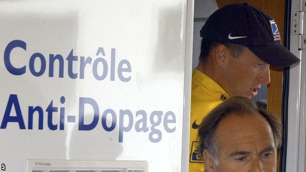 Lance Armstrong walks out of the Tour de France's anti-doping control bus