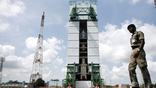 A paramilitary soldier walks past the Polar Satellite Launch Vehicle (PSLV-C25) at the Satish Dhawan Space Center at Sriharikota, in the southern Indian state of Andhra Pradesh, Wednesday, Oct. 30, 2013.