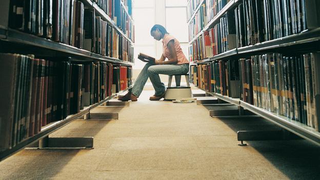 Young woman reading in library