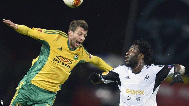 Kuban defender Angel Dealbert (L) jumps for the ball with Swansea forward Wilfried Bony