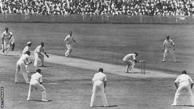 Australia captain Bill Woodfull ducks a short delivery from Harold Larwood with a "Bodyline" field in place