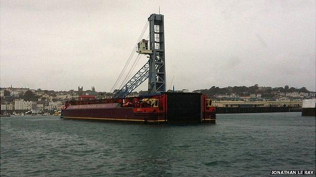 Mobile crane on barge entering Guernsey's St Peter Port Harbour