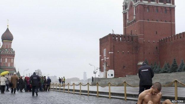 Performance artist Pyotr Pavlensky (bottom right) sits nailed to Red Square, 10 November