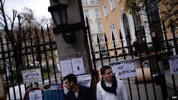 Students stand outside a locked gate of Sofia University, 11 November