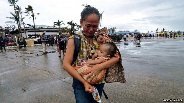 A woman is evacuated from the Philippine island of Leyte after the typhoon, 12 November 2013