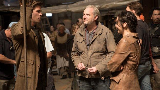 Director Francis Lawrence (centre) on set with Liam Hemsworth (left) and Jennifer Lawrence (right)