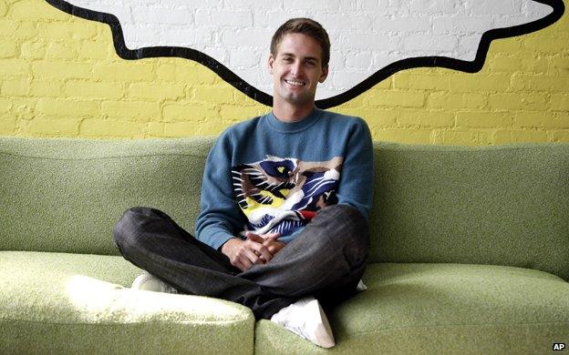 Evan Spiegel sits under the Snapchat logo