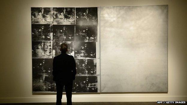 A man looks at Andy Warhol's Silver Car Crash painting