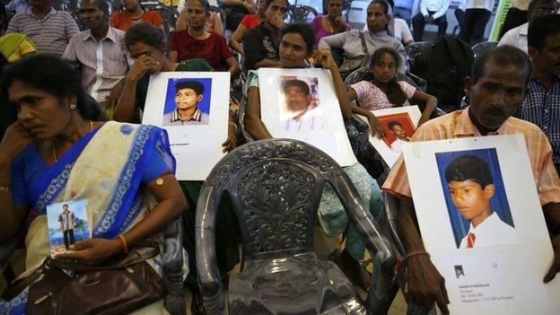 People belonging to the Sri Lankan minority Tamil ethnic group hold up photos of their relatives who disappeared during the Sri Lankan civil war