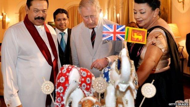 Prince Charles, Prince of Wales (centre) is presented with a birthday cake topped with three Elephants, by the President of Sri Lanka Mahinda Rajapaksa