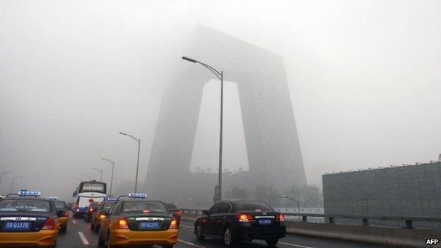 This picture taken on 5 June 2013 shows vehicles under heavy smog in Beijing