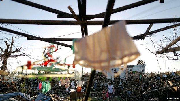 Typhoon survivors outside the ruins of their home, Tacloban (15 Nov)