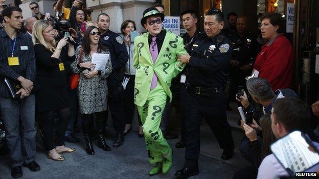 A man dressed as The Riddler is taken away by a San Francisco police officer after being apprehended by five-year-old leukaemia survivor Miles dressed as Batkid in San Francisco on 15 November 2013