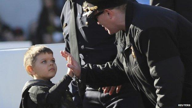 Batkid is congratulated by the cops at AT&T Park on 15 November 2013