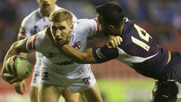 Sam Tomkins is tackled by Eloi Pelissier