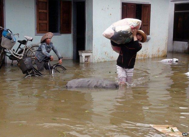 Residents rescue their belongings from a flooded house in Qui Nhon city, Binh Dinh province, Vietnam, 16 November