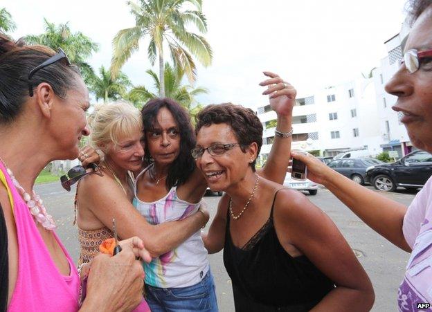 Francis Collomp's wife Anne-Marie (centre) celebrates news of her husband's freedom with relatives on the French Indian Ocean island of Reunion, 17 November