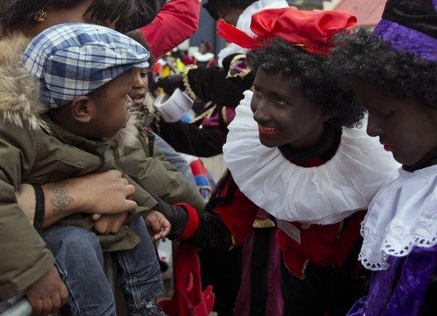 Black Pete revellers in costume meet a family in Amsterdam, 17 November