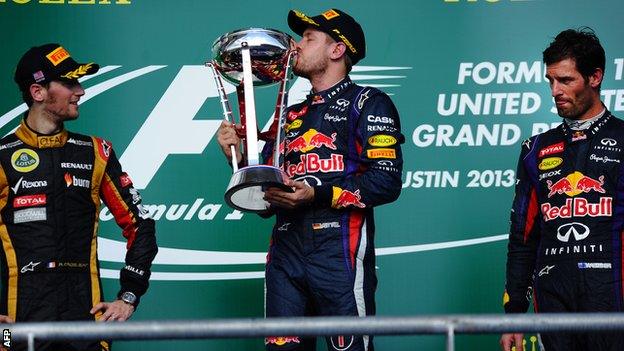 Sebastian Vettel celebrates alongside second-placed Lotus driver Romain Grosjean and his teammate third-placed Mark Webber