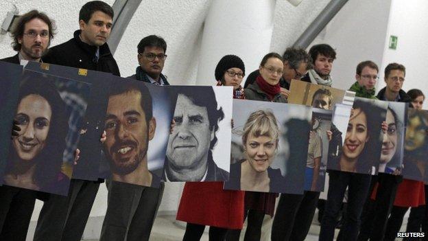 Greenpeace activists hold pictures showing the 30 people arrested in Russia over a protest against Arctic oil drilling on November 13, 2013