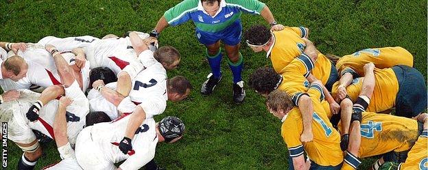 Referee Andre Watson speaks to the two front rows as they prepare for a scrum