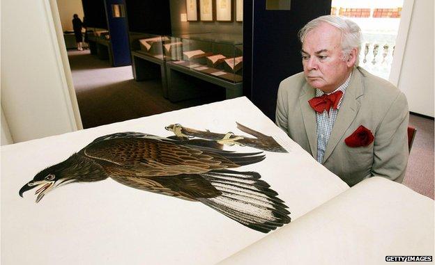 International art critic Patrick McCaughey inspects a print of a White-Headed Eagle in John James Audubon's 'Birds of America' from 1821